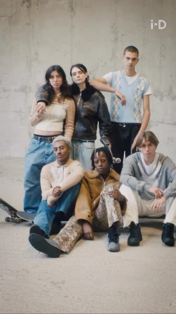 Group of six young models posing together against a textured concrete wall, photographed by Lola and Pani.