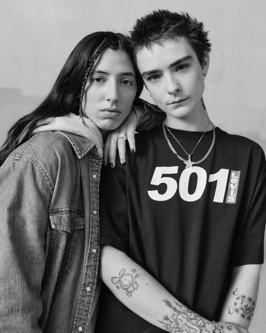A black and white portrait featuring a couple wearing casual clothing. The male wears a tee-shirt with '501' printed on it.