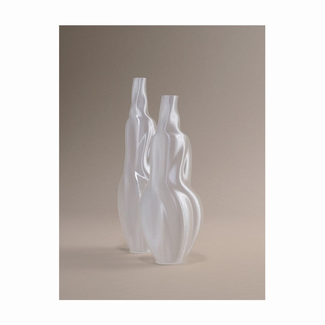 Elegant still life features two translucent glass vases with unique, asymmetrical shapes against a soft, neutral backdrop creating depth.