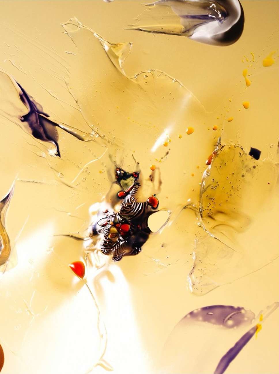 Abstract close-up of smears of translucent gel and paint creating an artistic design with bright colors and a wet look.