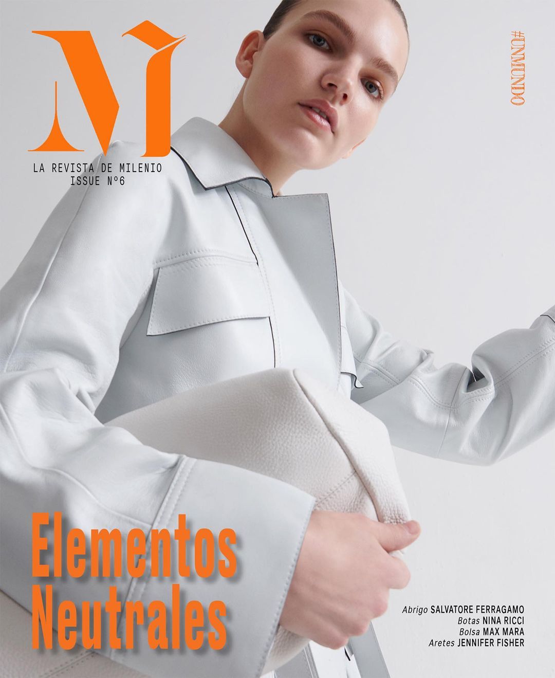 Magazine cover featuring a female model wearing a light-colored jacket and holding a matching purse, with bold orange text overlay.