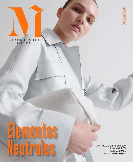 Magazine cover featuring a female model wearing a light-colored jacket and holding a matching purse, with bold orange text overlay.