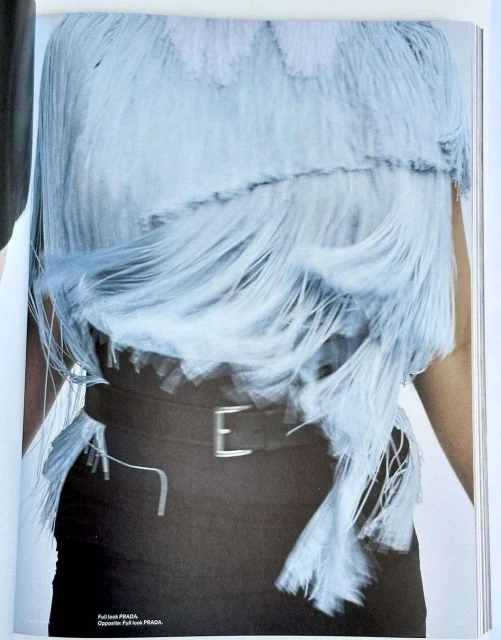 Fashion editorial shot featuring an adult woman in a fringe top and black skirt with belt in a studio environment.