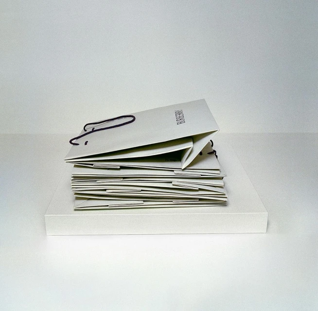 Stack of Burberry branded shopping bags in neutral tones against a white background. Fashion brand marketing still life image.