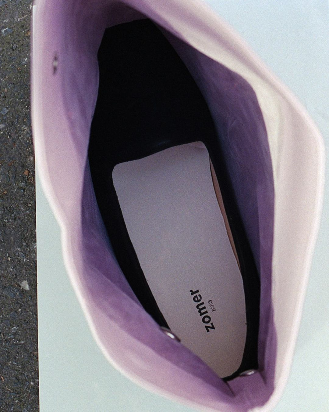 Open off-white tote bag with a black interior and a white liner with the brand name printed on it.