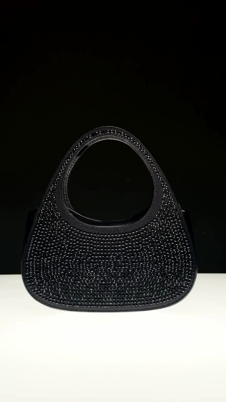Elegant black beaded evening bag with a rounded shape and short handle, set against a gradient of black and white background.