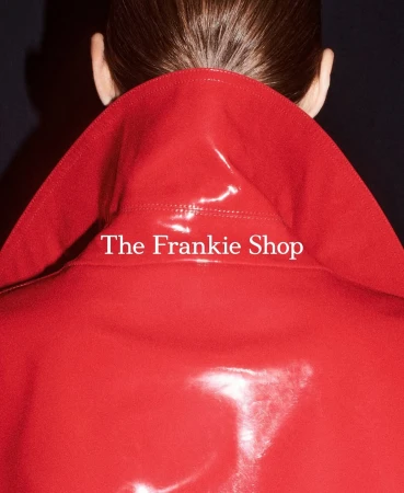 Close-up back view of a person wearing a glossy red patent leather coat with a high collar, photographed by Louis De Roffignac in Paris.