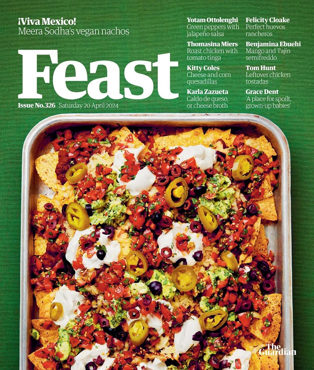 Overhead shot of vegan nachos in a silver pan: tortilla chips, guacamole, tomato salsa, jalapenos, olives, and sour cream.