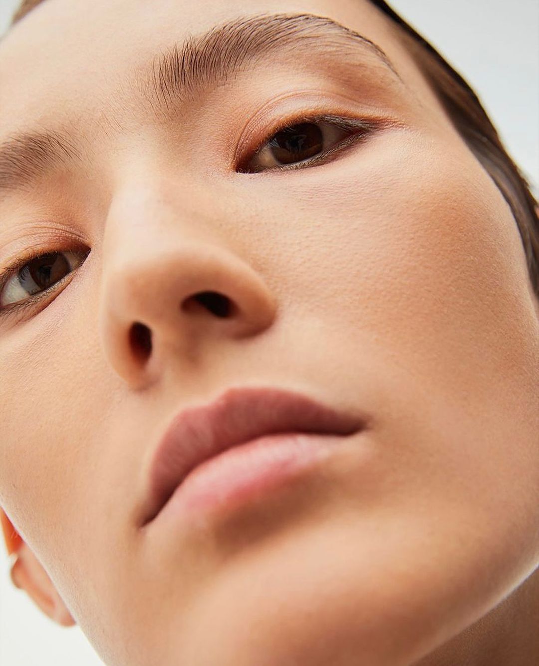 Extreme close-up portrait of a woman face shot from below with soft natural lighting by Luba Kozorezova in Paris.