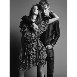 Monochrome portrait of a young man and woman posing together against a plain grey studio backdrop by Luca Bellumore.