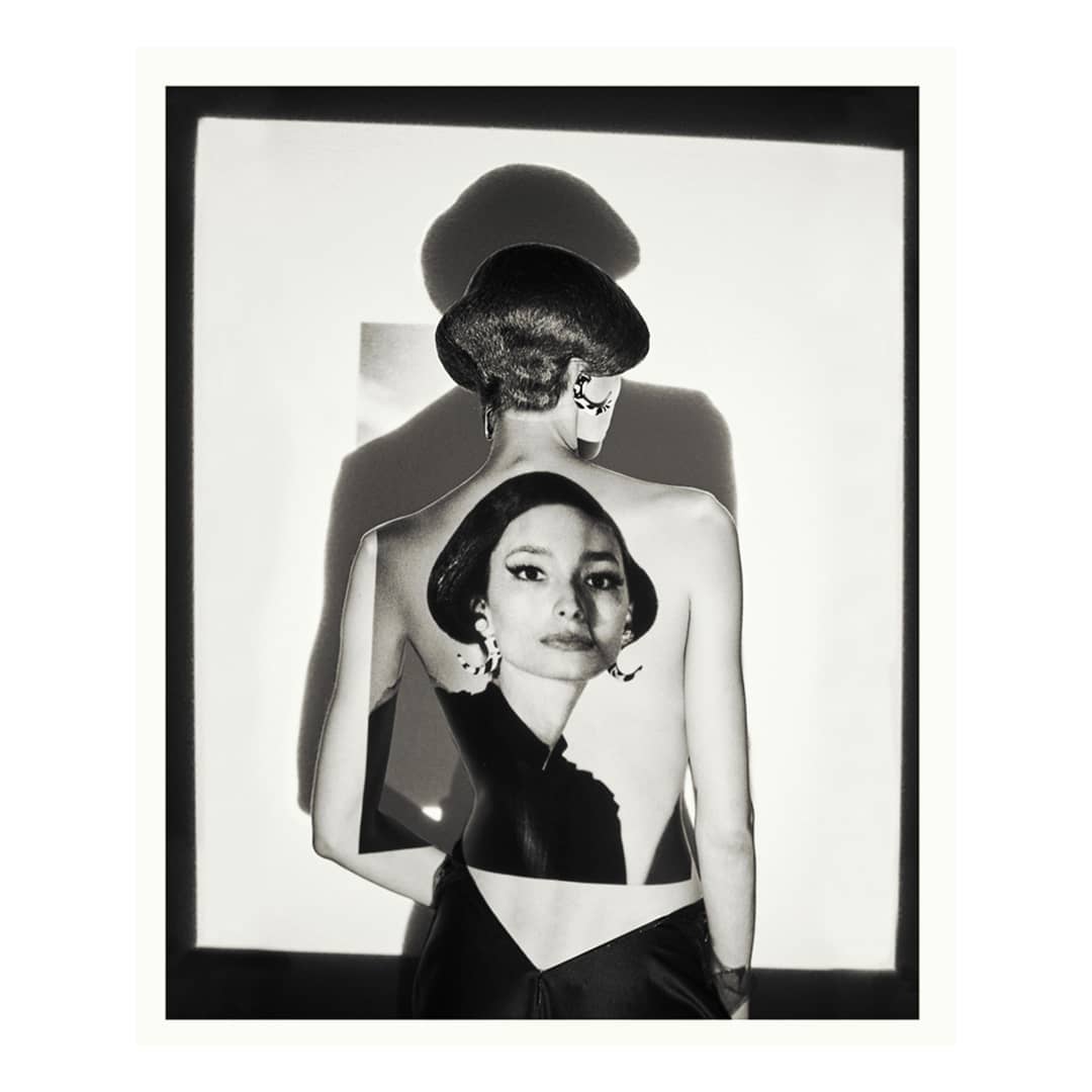 Black-and-white photograph featuring a woman with an updo, seen from behind, with a striking image of a woman superimposed on her back.