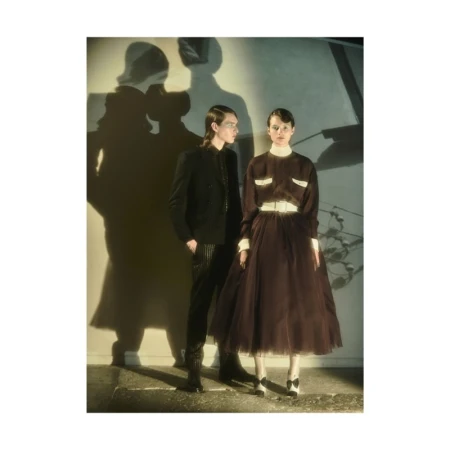 Two models standing against a wall with prominent shadows cast behind them in a photographic portrait by Lucian Bor.