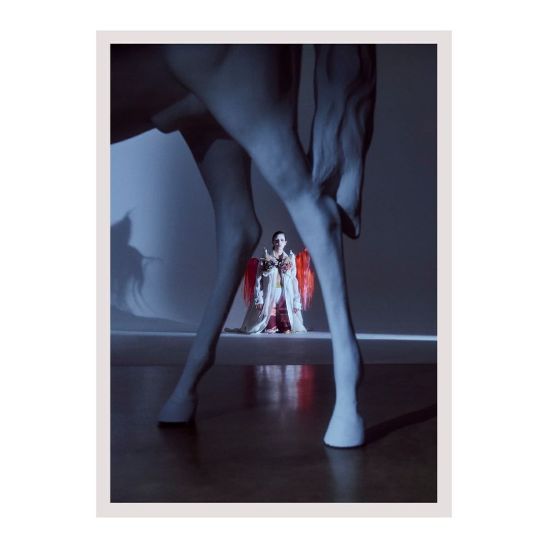 Fashionable figure poses between horse legs, striking a pose in a photo studio with vibrant colors and dramatic lighting.