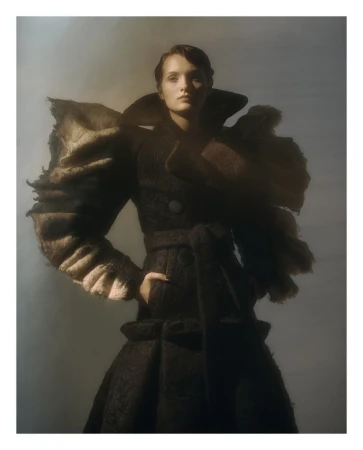 Model wearing a dark structured coat with sculptural frayed shoulders photographed by Lucian Bor in Paris.