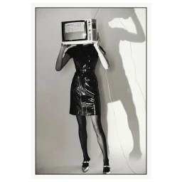 Model wearing a shiny black dress with a vintage television over their head instead of a face against a plain background.