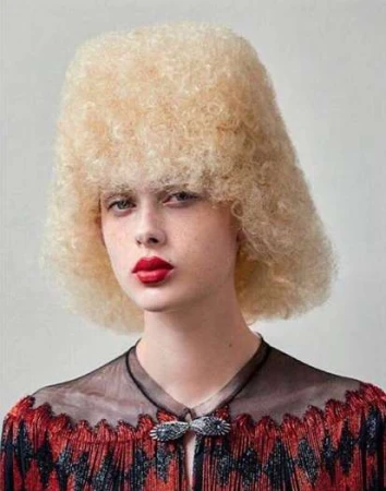 Portrait of a model with voluminous blonde textured hair and red lips wearing a decorative patterned top, by Lucian Bor.