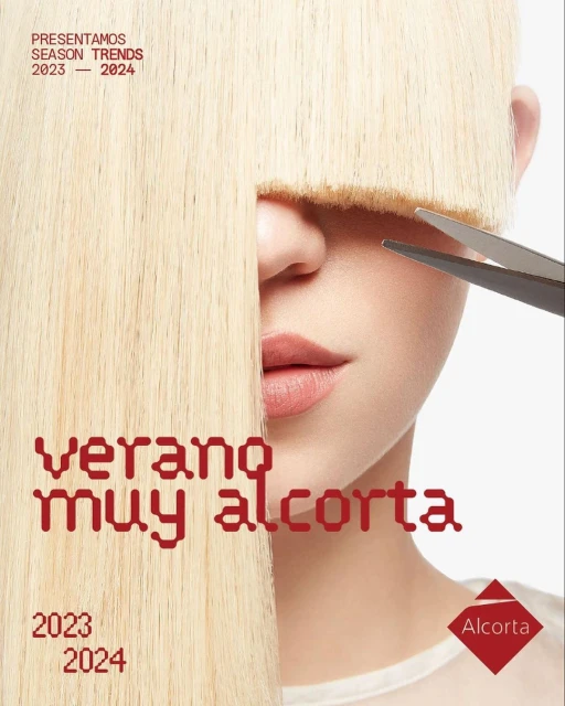 Woman's face is partially obscured by her straight, blond hair and blunt bangs, and someone is cutting her hair with scissors.