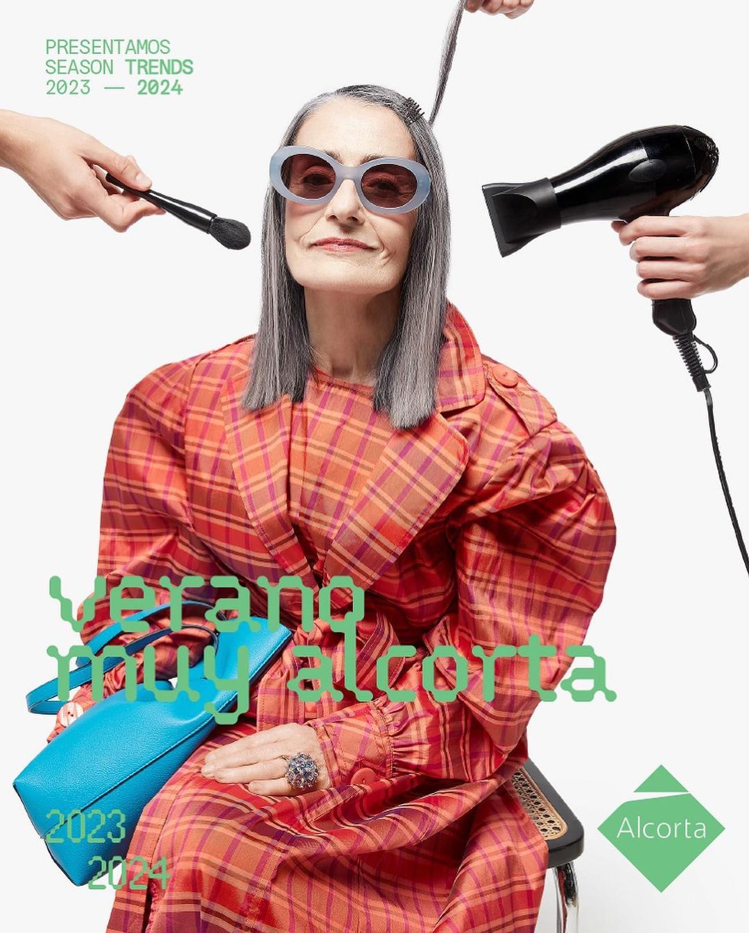 Elderly woman in plaid jacket and sunglasses sitting with purse. Hair stylist and make up artist styling her hair for photoshoot.