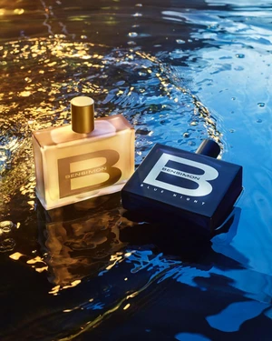 Two rectangular Bensimon perfume bottles resting on a reflective, rippling wet surface with blue and golden lighting.
