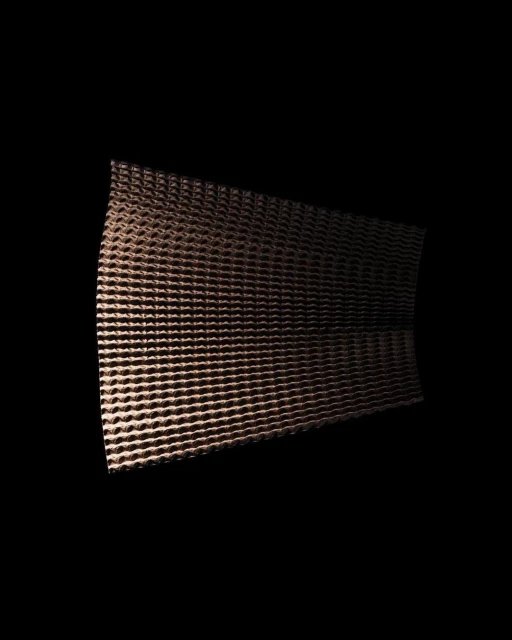 Textured copper-colored metal sheet featuring evenly spaced holes, illuminated against a stark black background. Abstract metal texture.