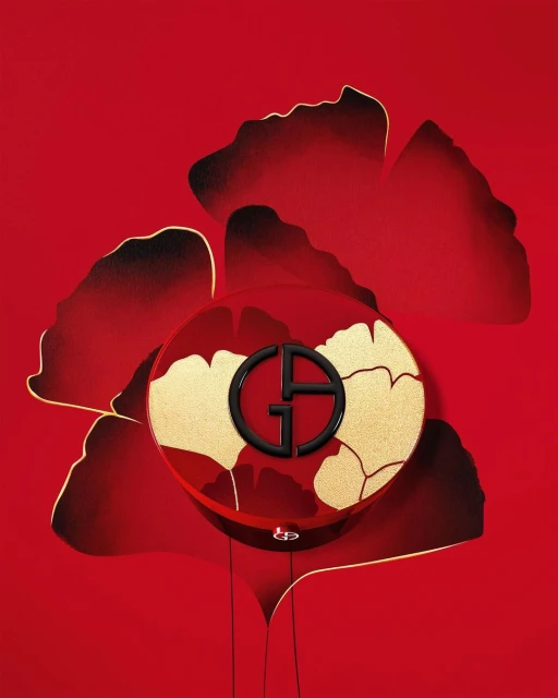 Giorgio Armani beauty product features a compact with a black logo on a gold and red floral background. The product is displayed on red.