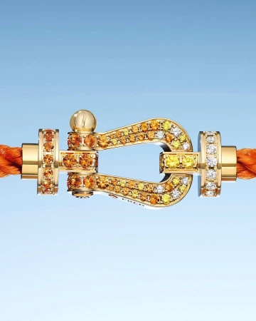 Close-up of a gold clasp bracelet with embedded diamonds, set against a light blue gradient background, showcasing jewelry design.