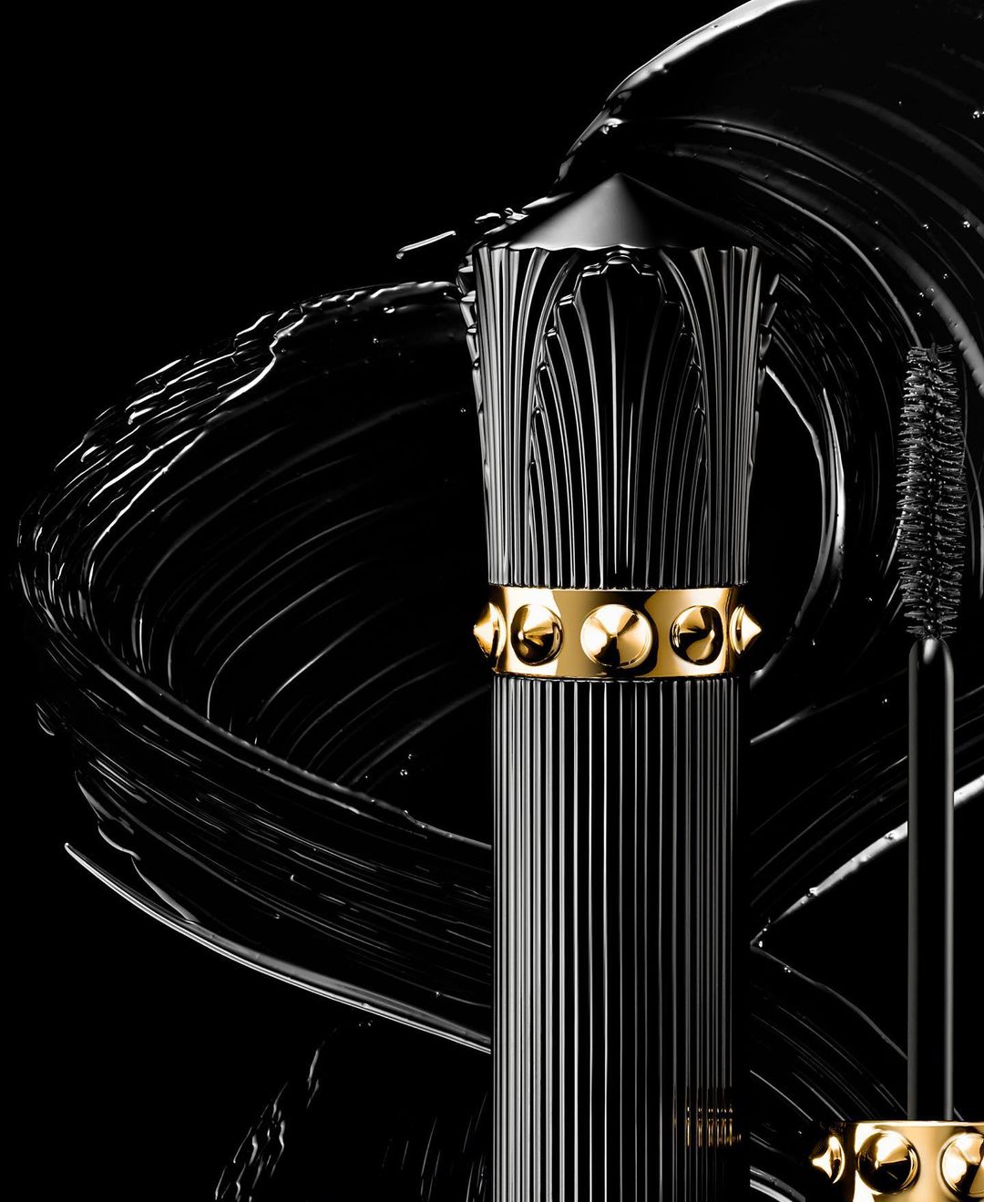 Black mascara product shot with gold accents and a textured black background, suitable for beauty and cosmetic campaigns.