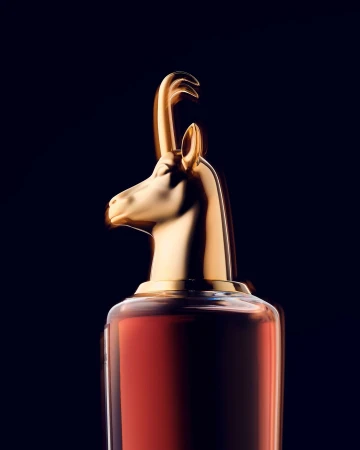 Elegant presentation of a perfume bottle with a golden animal-shaped cap against a dark backdrop, creating a luxurious aesthetic.