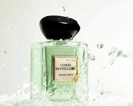 Armani Prive Cypres Pantelleria perfume bottle surrounded by splashing water on a bright white background.