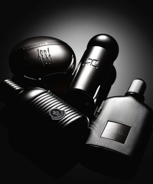 Elegant display of perfume bottles, showcasing Cerruti 1881, AC, Moncler, and Tom Ford Noir against a dark, gradient backdrop.