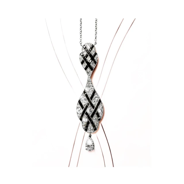 Elegant necklace with a woven pattern of black and clear gemstones on a delicate silver chain, displayed against a simple background.