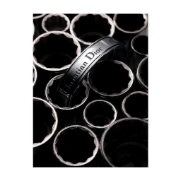 Close-up macro shot of a metallic branded ring resting vertically among dark mechanical socket tools.