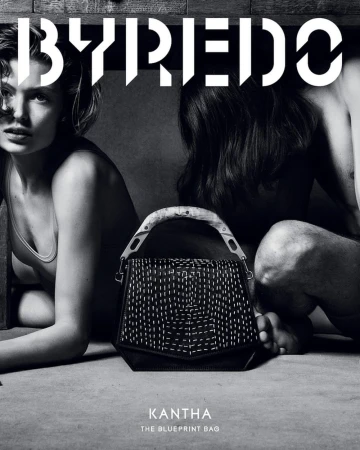Byredo campaign features a black leather Kantha bag with white stitching between two models in a neutral setting, showcasing fashion and design.