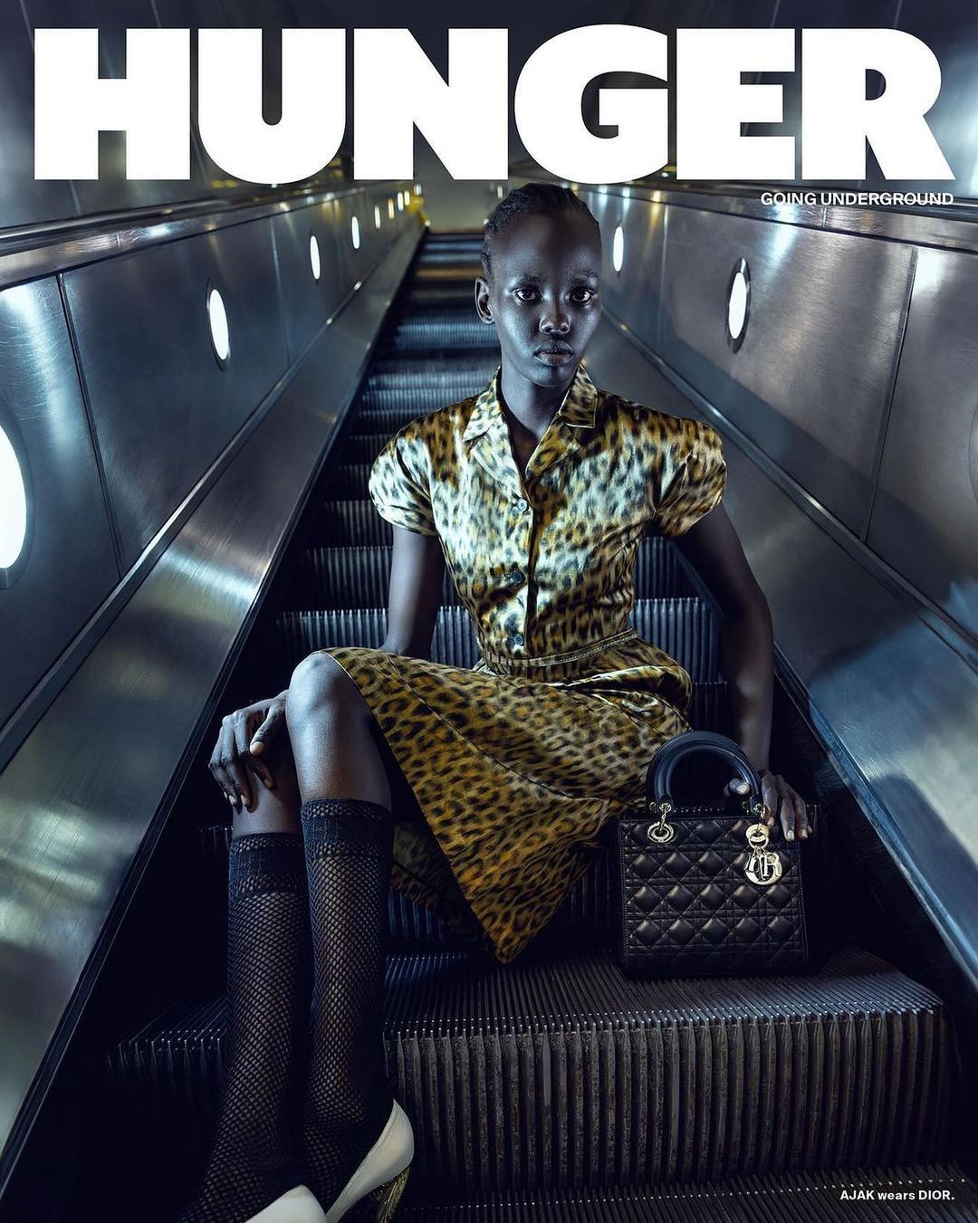 Hunger magazine cover featuring a woman in an animal print dress and black and white heels on an escalator holding a black bag.