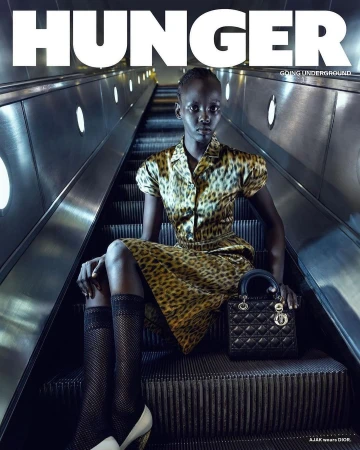 Hunger magazine cover featuring a woman in an animal print dress and black and white heels on an escalator holding a black bag.