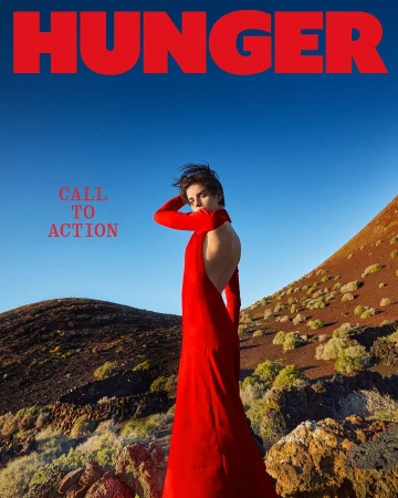 Fashion editorial cover for Hunger magazine, featuring a woman in a red dress against a backdrop of clear blue sky and volcanic landscape.