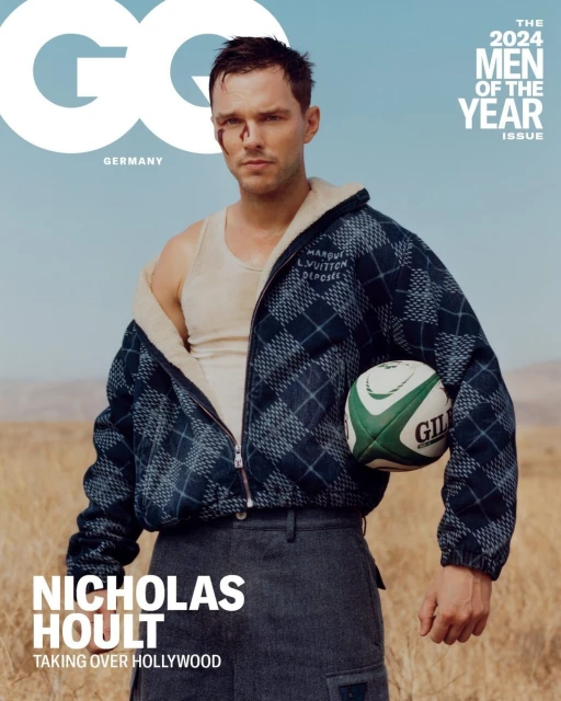 Nicholas Hoult on GQ Germany cover, 2024 Men of the Year issue, holding rugby ball, wearing jacket, tank top, in arid field.