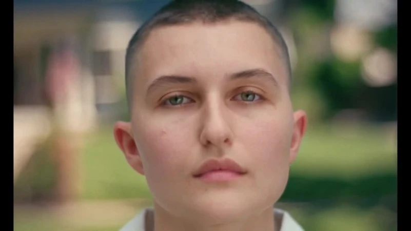 Close-up portrait of a white person with a buzz cut and green eyes by Luke Gilford