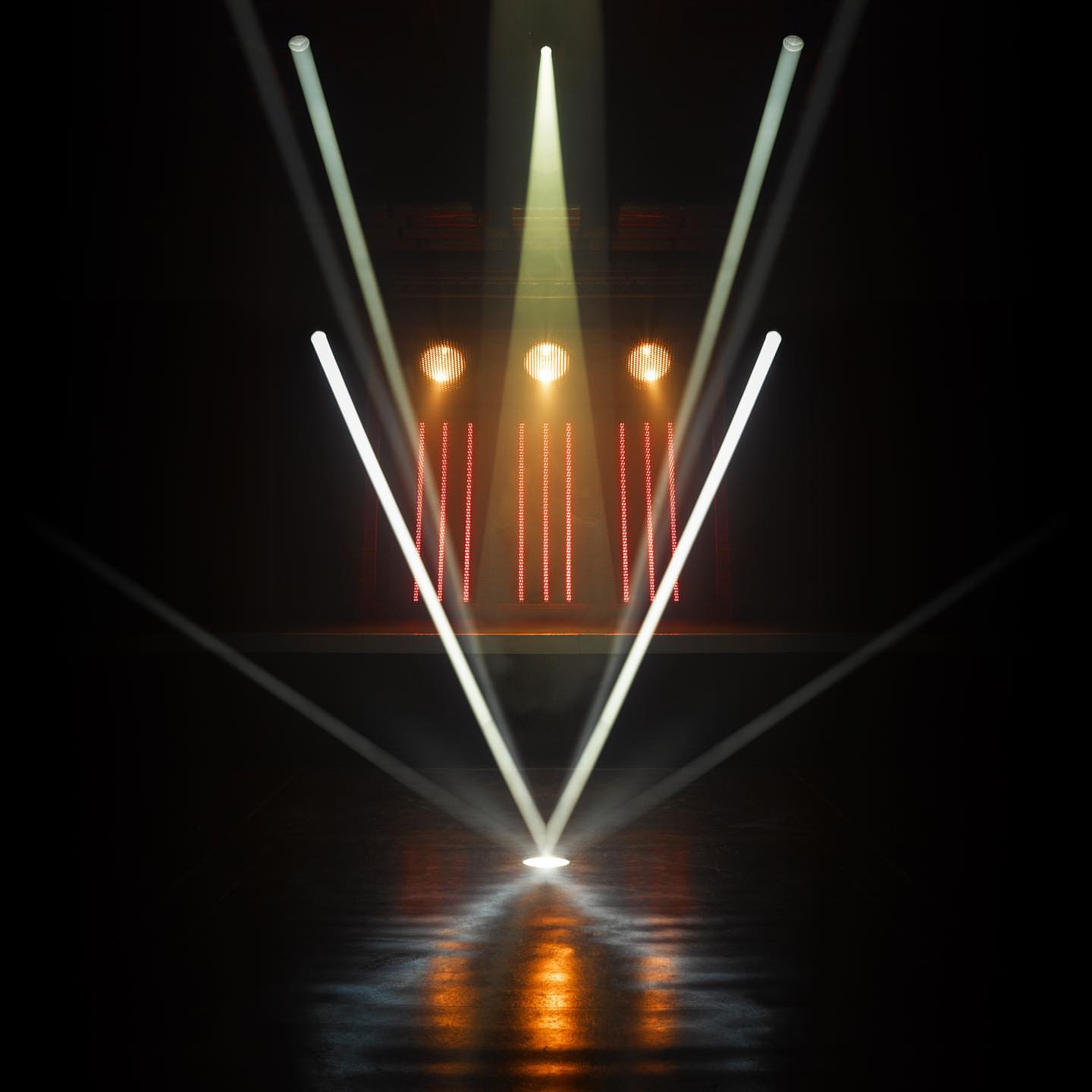 Stage lighting display with a dark background features white and yellow beams of light angled downward, creating a modern, bright design.