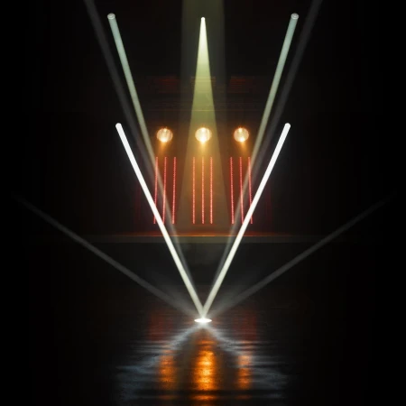 Stage lighting display with a dark background features white and yellow beams of light angled downward, creating a modern, bright design.