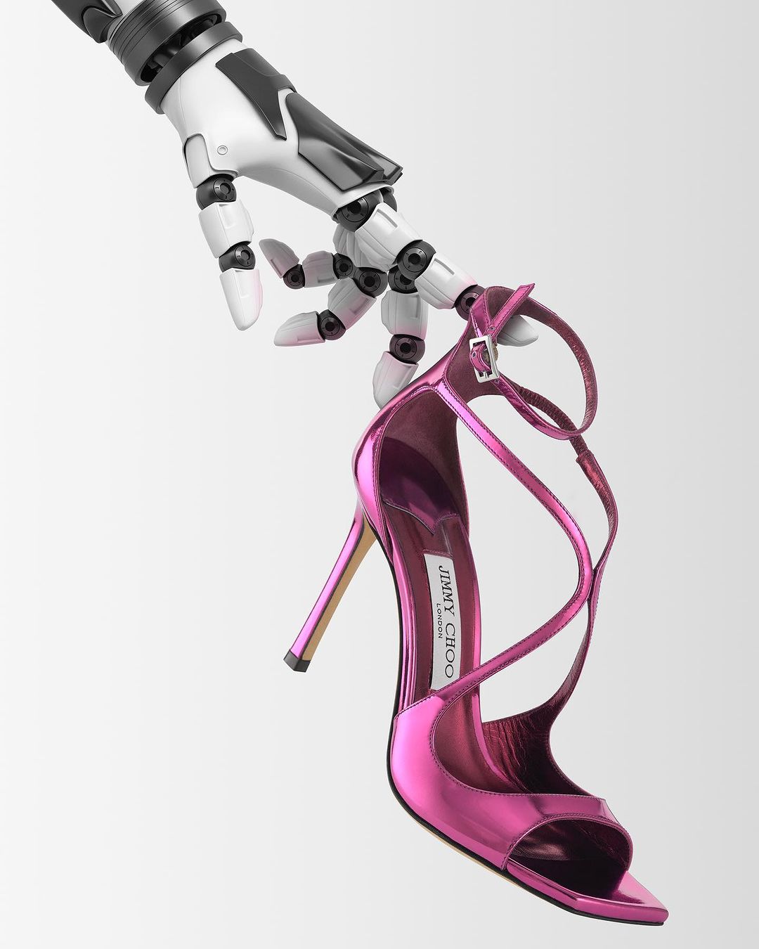 High heel shoe by Jimmy Choo held by a robot hand against a gradient white background. Fashionable footwear and artificial intelligence.