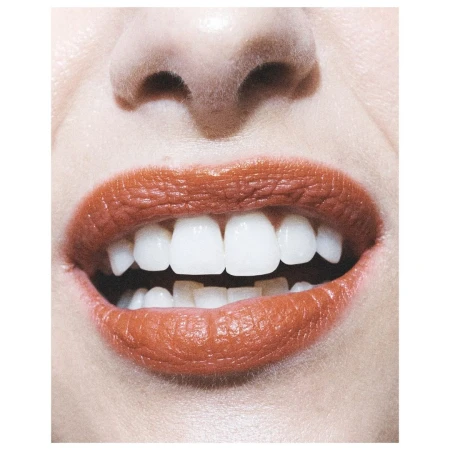 Close-up of a woman's face highlighting the mouth with lipstick and showing straight, white teeth, focusing on dental aesthetics.