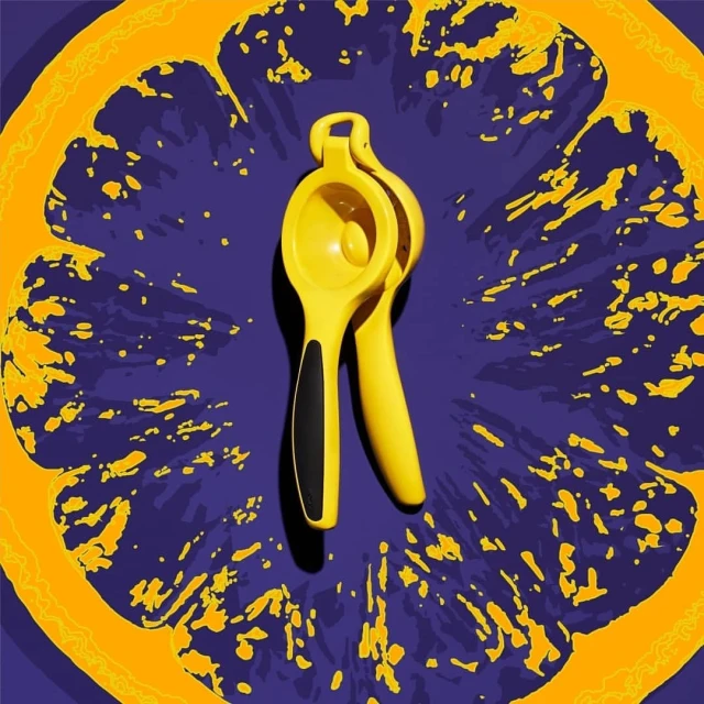 Yellow lemon squeezer on a vivid purple backdrop with an abstract orange slice design, creating a vibrant and eye-catching food photography image.