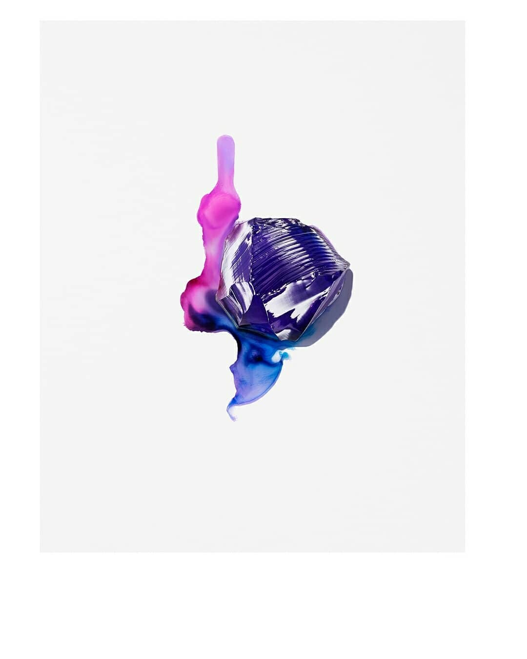 Studio shot of a faceted translucent object with violet, pink, and blue fluid on a solid white backdrop, minimalist composition.