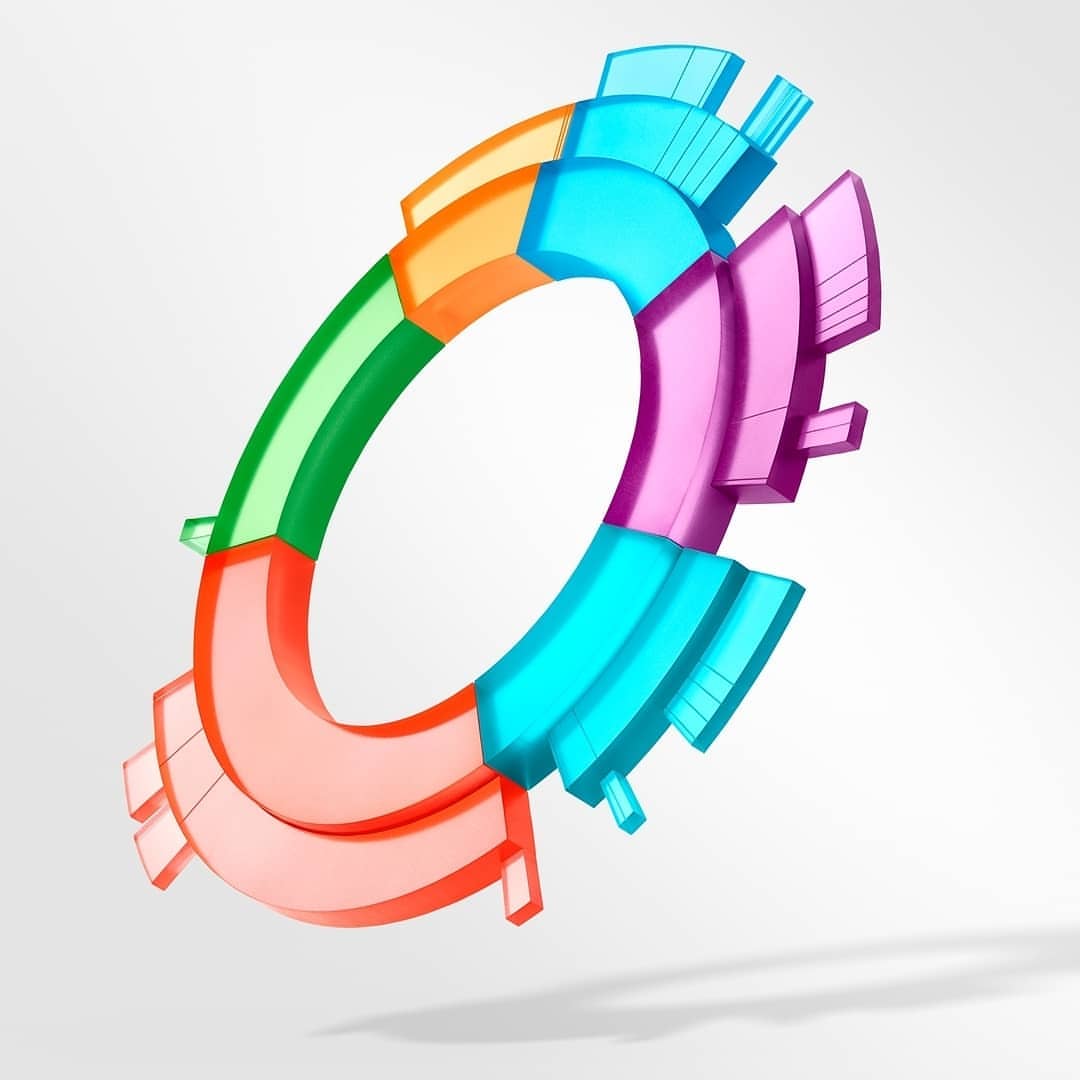 Abstract 3D render of a multi-colored ring structure with green, red, orange, blue, and purple sections against a pale grey gradient background.