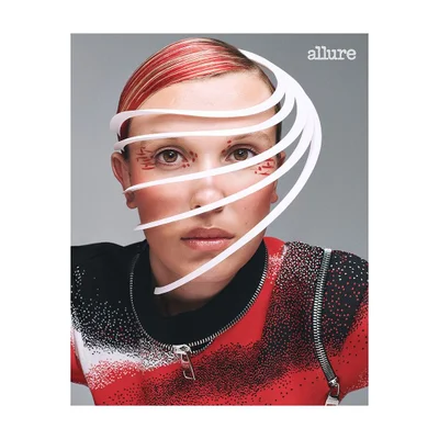 Close-up portrait of Millie Bobby Brown with white curved paper strips framing her face and red eye makeup by Lydia Shirreff.
