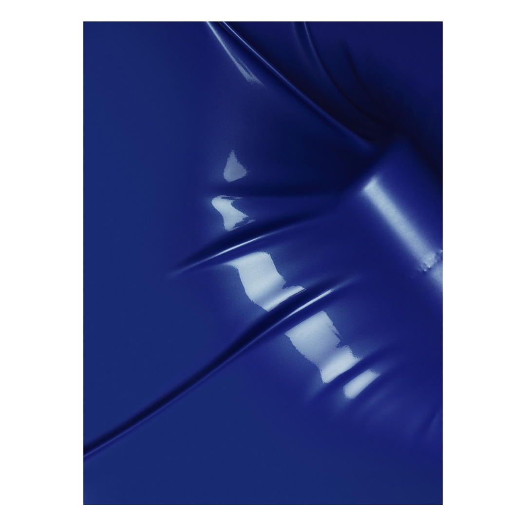 Close-up of vibrant, glossy royal blue fabric with intricate folds and dramatic shadows creating a dynamic, abstract, textured pattern.