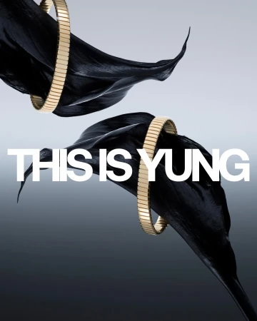 Elevated product shot of golden bracelets adorning black calla lilies against a soft gradient background, showcasing luxury and elegance.