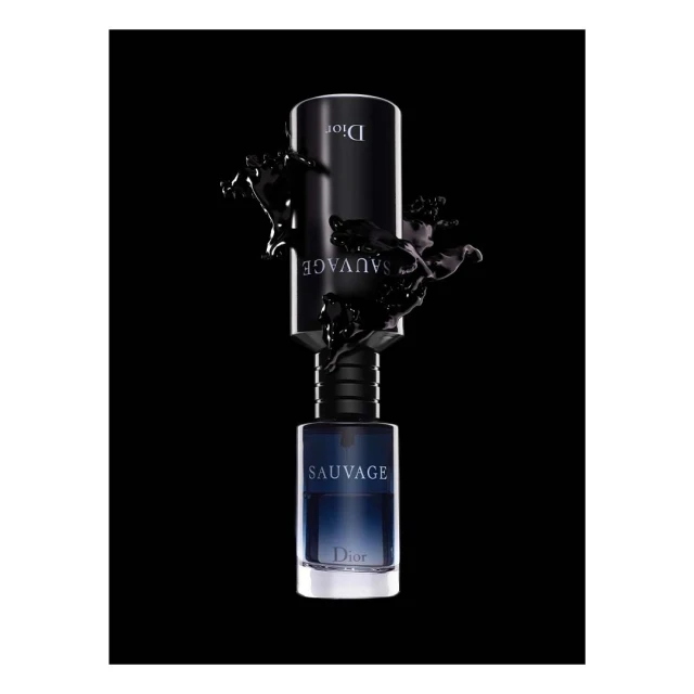 Dior Sauvage perfume bottle set against a black background with liquid splashes around it, product shot for beauty and fashion.