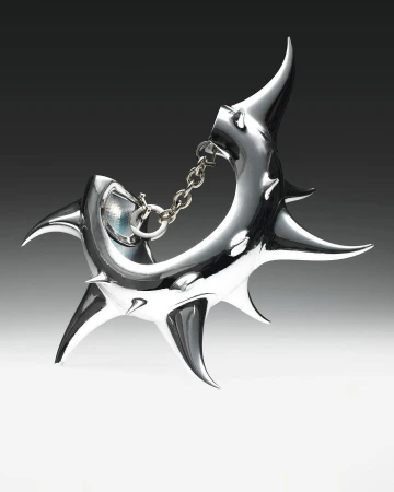 Close-up of a shiny, silver-colored abstract metal sculpture with pointed projections and a chain connection on a gradient background.